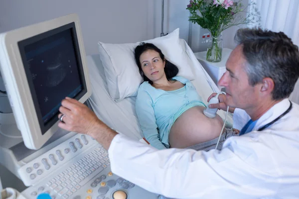 病院で妊婦のための超音波スキャンを行う白人男性医師の高角図 — ストック写真