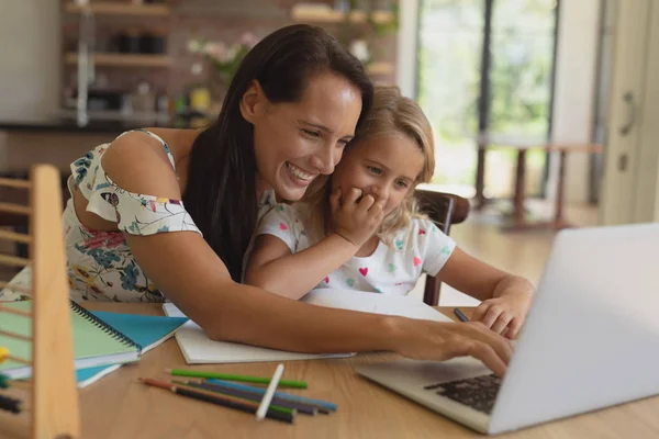 快適な家庭で娘の宿題を手伝う白人の母親の正面図 — ストック写真