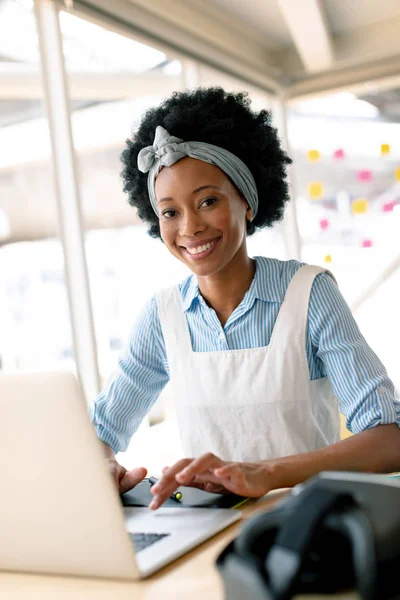 非洲裔美国女平面设计师在办公室办公桌上处理笔记本电脑的正面视图 — 图库照片