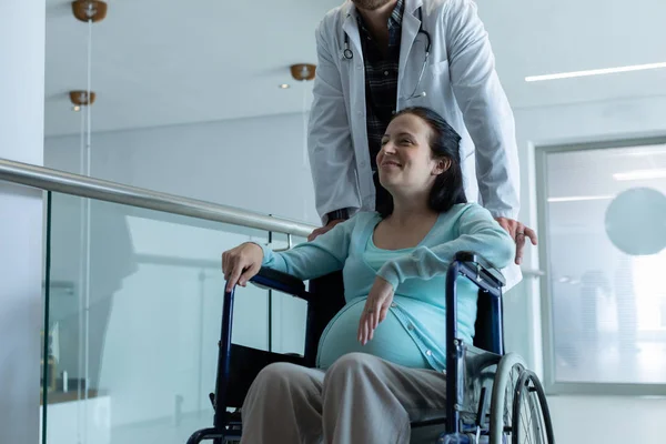 Front View Caucasian Male Doctor Pushing Pregnant Woman Wheelchair Corridor — Stock Photo, Image