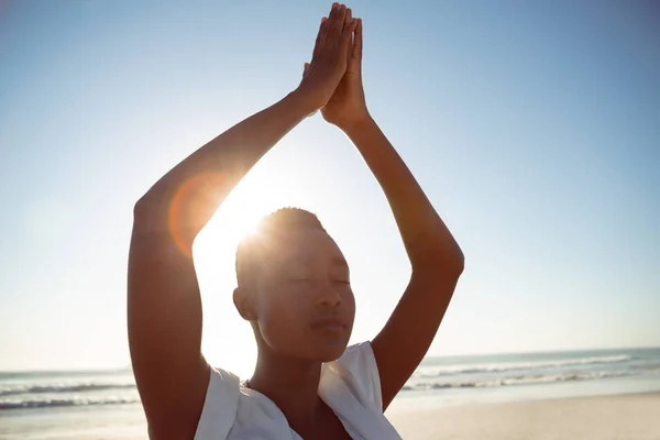 年轻的非洲裔美国妇女在沙滩上做瑜伽的前视图 — 图库照片