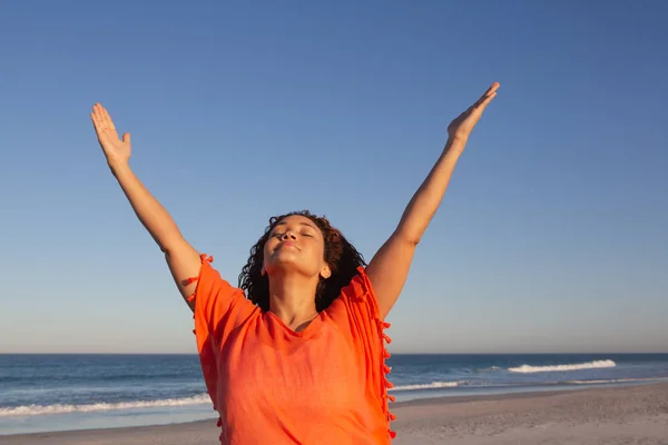 美丽的混血女人的前方景色 手臂站在阳光下的海滩上 — 图库照片
