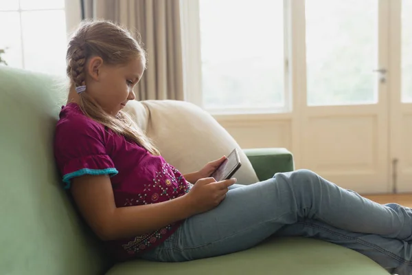 Oldalnézetből Aranyos Lány Segítségével Digitális Tabletta Kanapén Egy Kényelmes Otthon — Stock Fotó