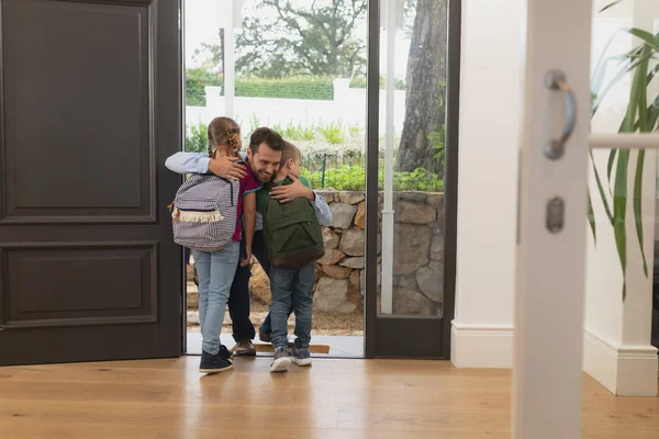 Vista Frontal Pai Caucasiano Abraçando Seus Filhos Porta Uma Casa — Fotografia de Stock