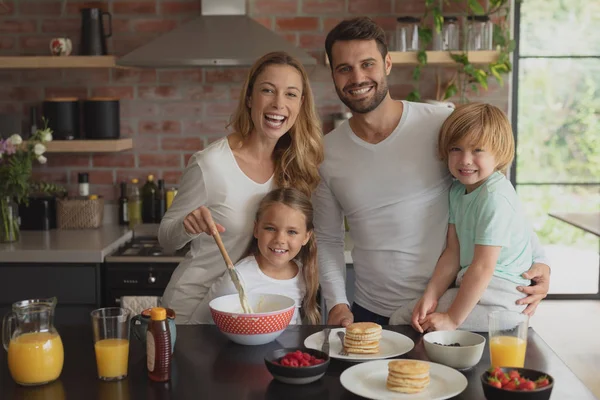 自宅のキッチンでワークトップで食べ物を準備する白人家族の正面図 — ストック写真