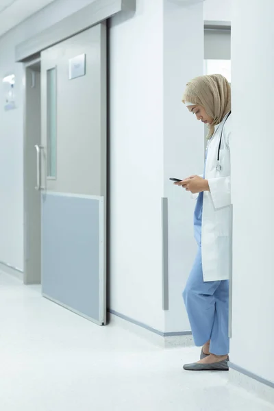 Vista Laterale Del Medico Razza Mista Hijab Utilizzando Telefono Cellulare — Foto Stock