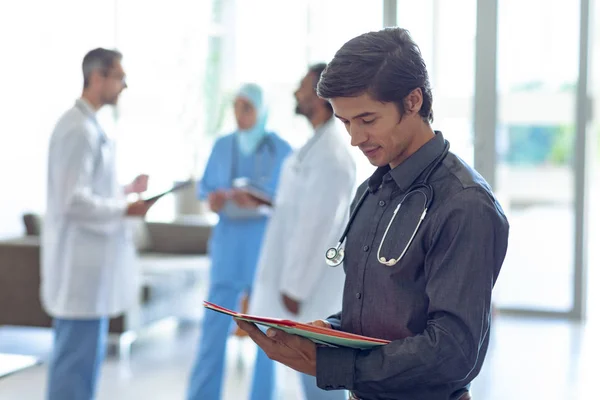 Pohled Kavkazský Mužský Doktor Který Dívá Lékařský Spis Nemocnici Pozadí — Stock fotografie