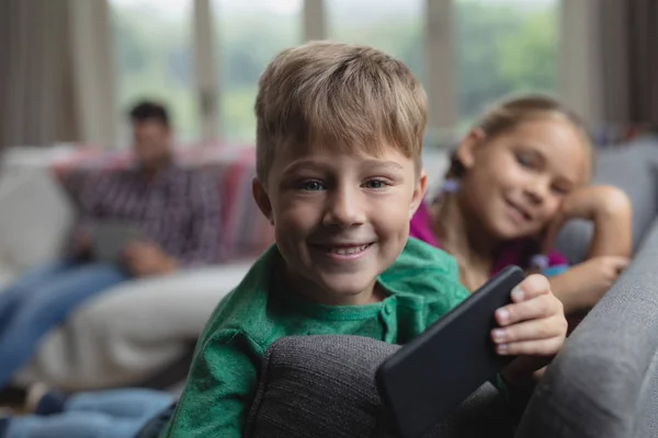 Framsidan Happy Cute Kaukasiska Pojke Med Mobiltelefon Tittar Kameran Soffan — Stockfoto