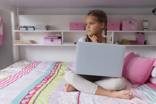 Framsidan Tankeväckande Kaukasiska Flickan Tittar Bort Medan Använder Laptop Sängen — Stockfoto