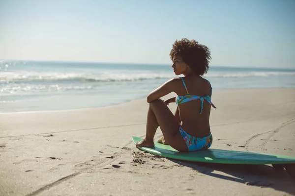 Vista Trasera Mujer Afroamericana Relajándose Tabla Surf Playa — Foto de Stock