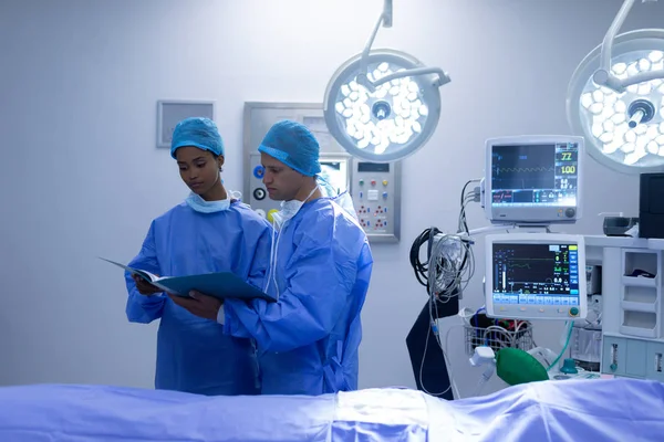 Visão Frontal Diversos Cirurgiões Discutindo Sobre Relatório Médico Sala Operações — Fotografia de Stock