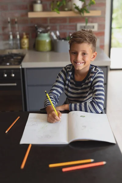 自宅の台所のテーブルで勉強する白人少年の肖像 — ストック写真