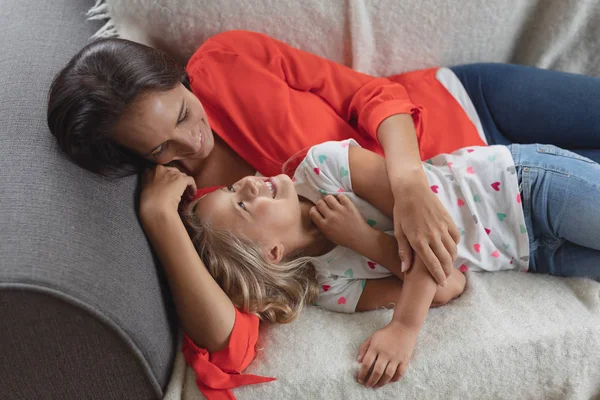 自宅のリビングルームのソファで一緒にリラックスする白人の母と娘の高い眺め — ストック写真