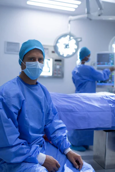 Vista Frontal Cirurgião Masculino Caucasiano Sentado Com Máscara Cirúrgica Teatro — Fotografia de Stock