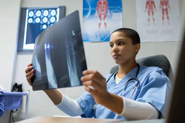 Framsidan Mixed Race Kvinnlig Läkare Undersöker Röntgen Rapport Skrivbord För — Stockfoto