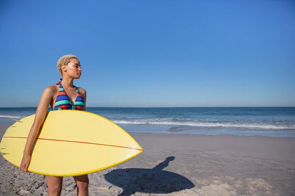 해변에서 서핑보드를 서있는 비키니를 아프리카 미국인 여성의 — 스톡 사진
