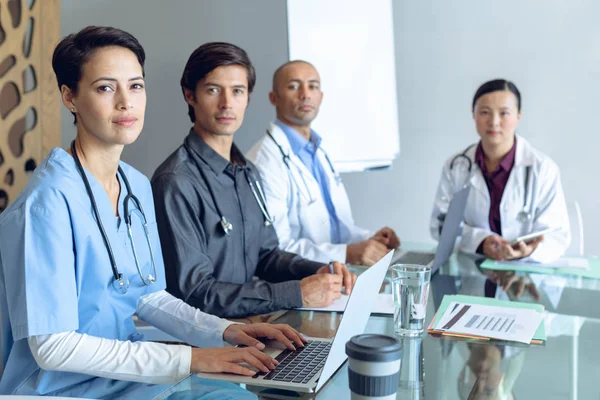 Vooraanzicht Van Diverse Medische Team Kijken Naar Camera Terwijl Zittend — Stockfoto