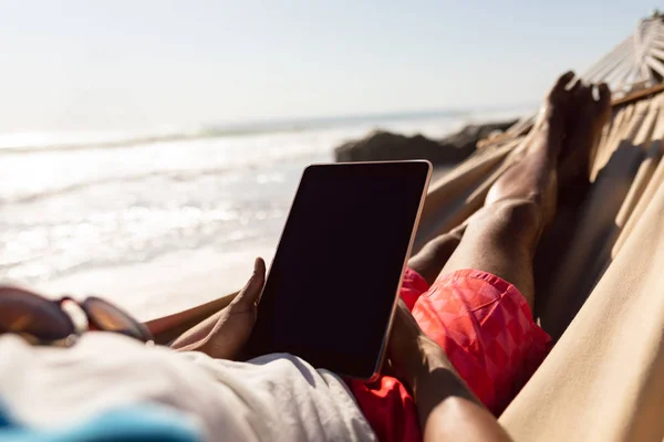 Baixa Seção Homem Usando Tablet Digital Enquanto Relaxa Uma Rede — Fotografia de Stock