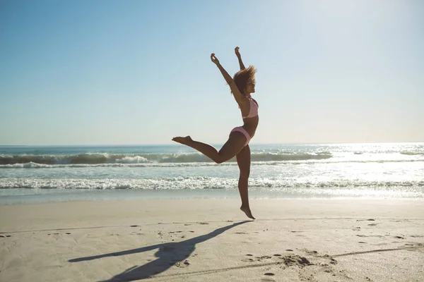 Вид Сбоку Красивой Африканской Женщины Прыгающей Пляже Солнечный День — стоковое фото