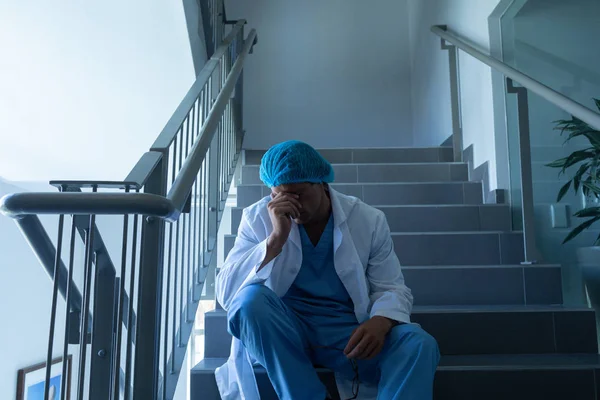 Front View Tensed Caucasian Male Surgeon Hand Forehead Sitting Stairs — Stock Photo, Image