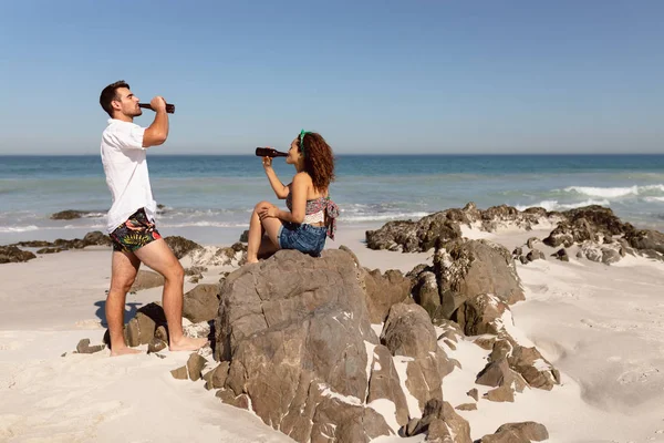 Vista Lateral Joven Pareja Raza Mixta Bebiendo Cerveza Playa Bajo — Foto de Stock