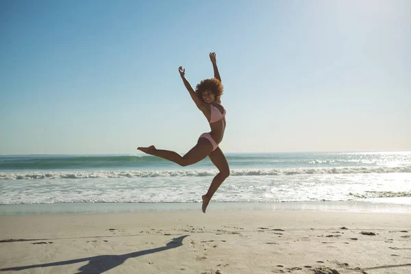 Вид Спереди Красивой Африканской Женщины Прыгающей Пляже Солнечный День — стоковое фото