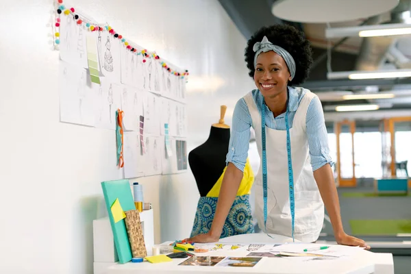 幸福的非洲裔美国女平面设计师靠在办公室的桌子上的正面视图 — 图库照片