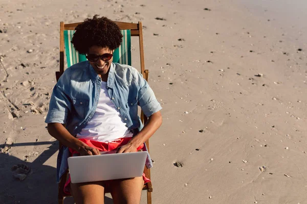 Widok Przodu Młodego Afroamerykanina Korzystającego Laptopa Podczas Relaksu Fotelu Plaży — Zdjęcie stockowe