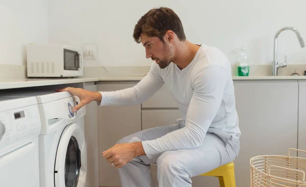 Vista Lateral Jovem Homem Caucasiano Limpando Roupas Máquina Lavar Roupa — Fotografia de Stock