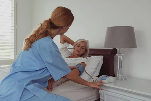 Bakifrån Kaukasisk Kvinnlig Läkare Kontrollerar Blodtrycket Hos Aktiv Äldre Kvinna — Stockfoto