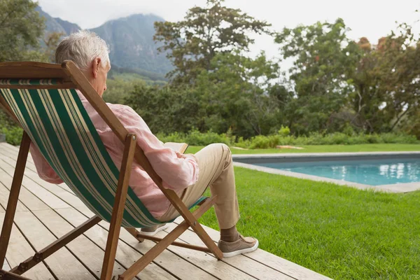 Rear View Active Senior Caucasian Man Reading Book While Relaxing — Stock Photo, Image