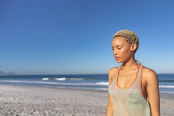 站在海滩上的深思熟虑的非洲裔美国妇女的侧视图 — 图库照片