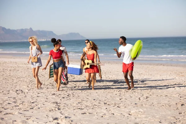 一群快乐的多元化朋友在沙滩上一起散步的前视图 — 图库照片