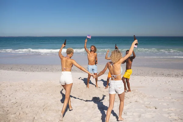 一群年轻的不同朋友在海滩上玩得开心的概述 — 图库照片