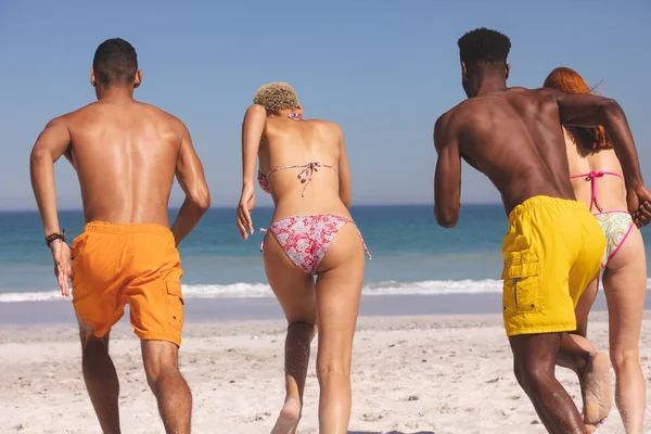 Achteraanzicht Van Diverse Vrienden Die Samen Het Strand Rennen — Stockfoto