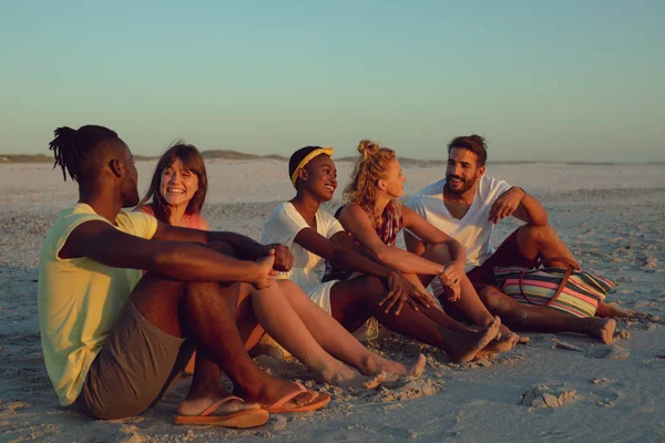 Vista Lateral Grupo Amigos Diversos Sentados Juntos Praia Durante Pôr — Fotografia de Stock