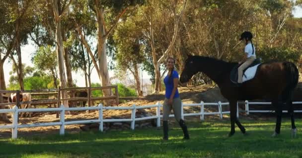 Mère aidant fille pendant l'équitation — Video