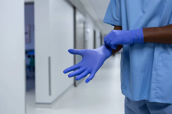病院の廊下で外科手袋を着用した男性外科医の中間部 — ストック写真