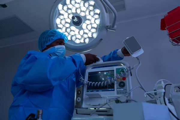 Vista Lateral Cirurgião Masculino Afro Americano Segurando Desfibrilador Sala Cirurgia — Fotografia de Stock