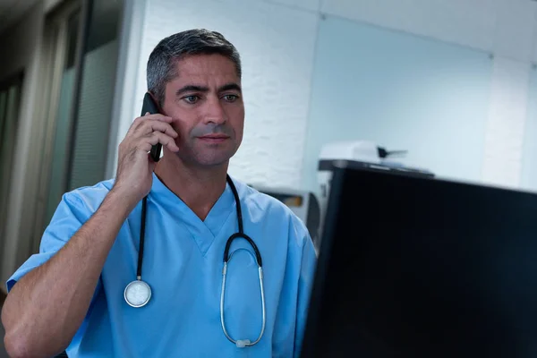Hastane Masasında Bilgisayar Üzerinde Çalışırken Cep Telefonu Konuşurken Kafkas Erkek — Stok fotoğraf