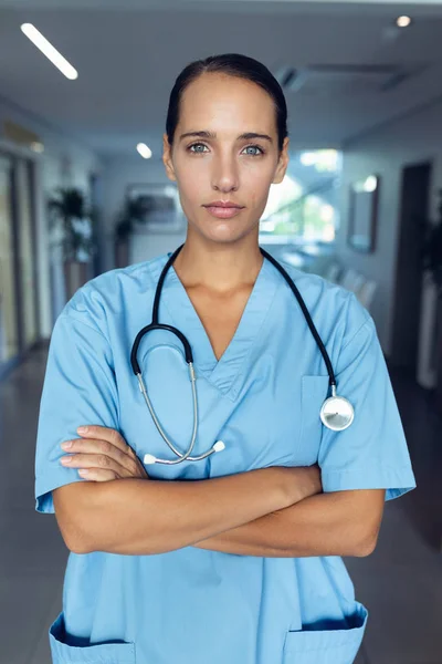 病院で腕を組んで立っている若い白人女性医師の肖像画 — ストック写真