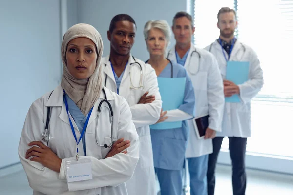 病院で腕を組んで立っている医療多様なチームの肖像画 — ストック写真