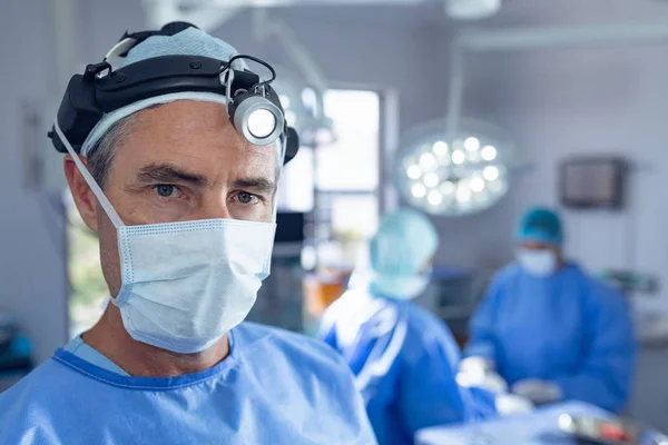 Portret Kaukaski Chirurg Chirurgiczny Stojący Podczas Gdy Różnorodne Chirurdzy Wykonujący — Zdjęcie stockowe