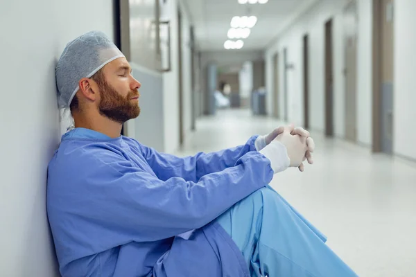 Widok Boku Napięte Kaukaski Mężczyzna Chirurg Siedzi Korytarzu Szpitalu — Zdjęcie stockowe
