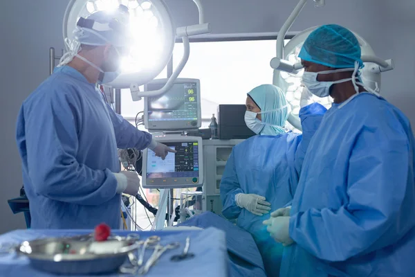 Hastanede Operasyon Tiyatrosunda Tıbbi Monitör Üzerinde Tartışan Çeşitli Cerrahların Yan — Stok fotoğraf