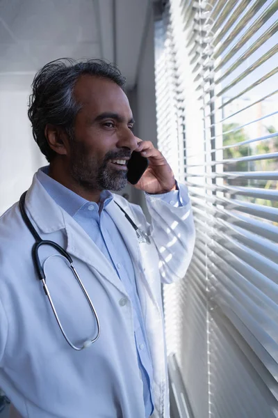 Hastanede Cep Telefonuyla Konuşan Mutlu Olgun Karışık Irk Erkek Doktor — Stok fotoğraf