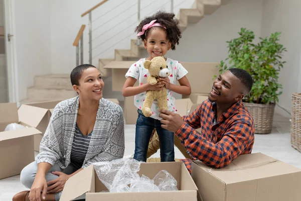 幸せなアフリカ系アメリカ人の家族の正面図自宅のリビングルームで段ボール箱を開梱 — ストック写真