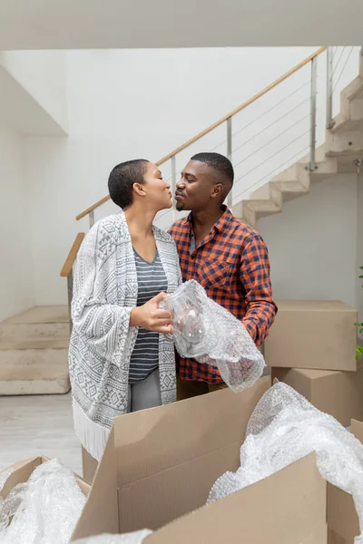 Framifrån Lyckliga Afroamerikanska Paret Kysser Varandra Medan Uppackning Kartong Lådor — Stockfoto