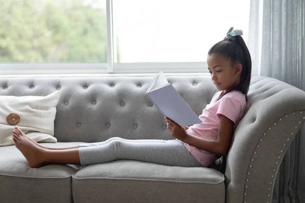 Evde Oturma Odasında Bir Kitap Okuma Afrikalı Amerikan Sevimli Kız — Stok fotoğraf