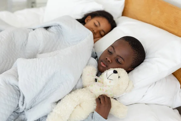 自宅の寝室でベッドで一緒に寝ているアフリカ系アメリカ人の兄弟の肖像画 — ストック写真